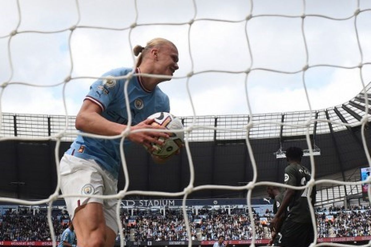 Bomber Manchester City, Erling Haaland, memungut bola dari tembakan rekannya Joao Cancelo seusai mencetak gol perdana pada pertandingan Liga Inggris melawan Southampton di Stadion Etihad, Sabtu (8/10/2022).