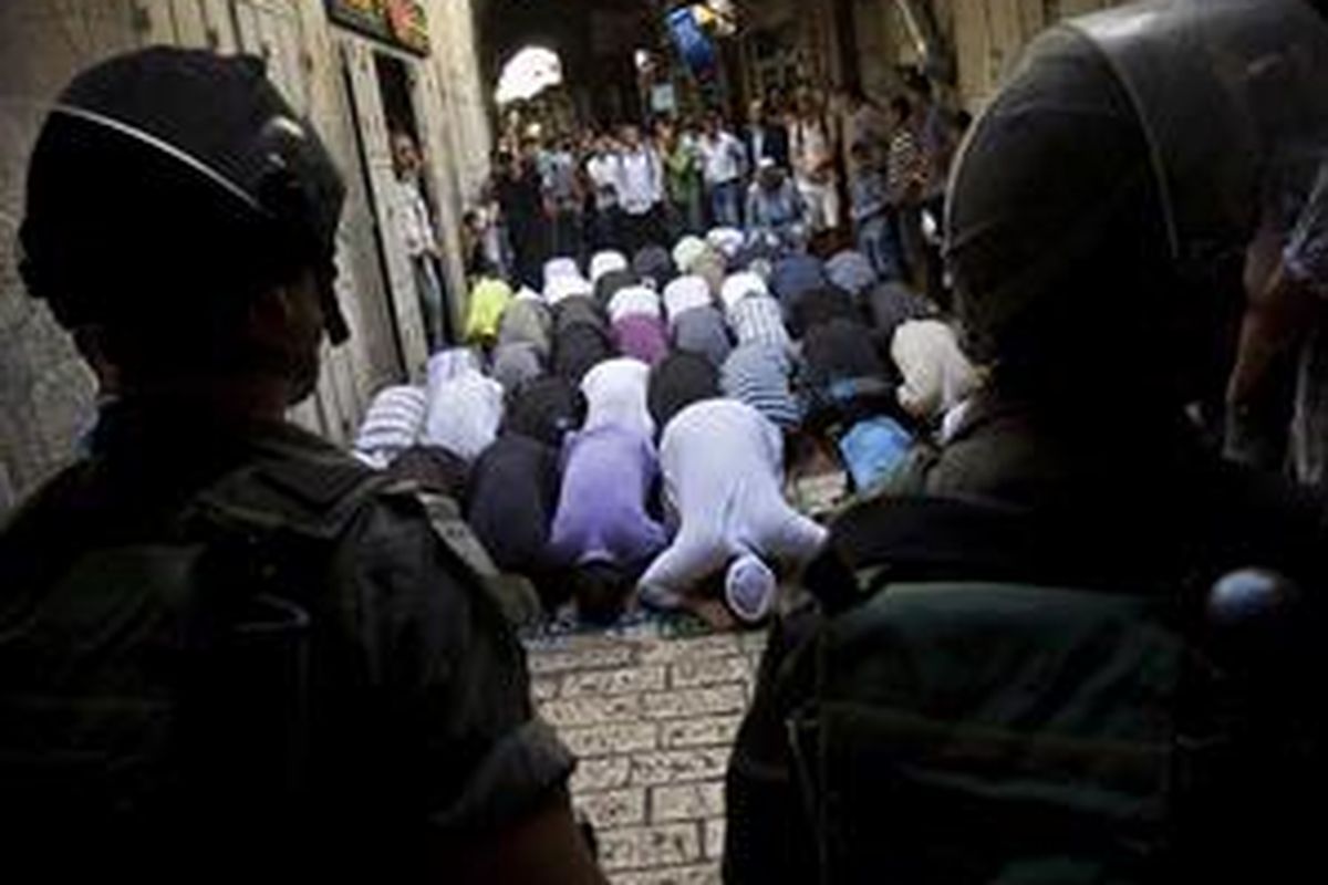 Warga shalat di depan aparat keamanan Israel karena dilarang mendekati Masjid Al-Aqsad di Kota Tua Jerusalem, menyusul bentrok antara umat Muslim dan Yahudi di kompleks masjid itu, Minggu, 27 September 2009.