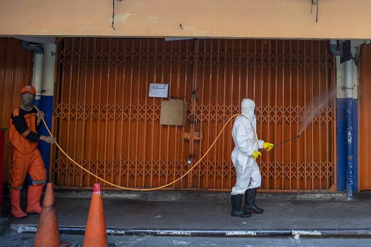 Petugas kebersihan menyemprotkan cairan disinfektan di area Pasar Asem Reges, Jakarta Barat, Selasa (21/7/2020). Pengelola Pasar Asem Reges menutup sementara pasar tersebut dari Senin (20/7) hingga Rabu (22/7) menyusul satu orang pedagang terkonfirmasi positif COVID-19 berdasarkan hasil tes usap (swab test).