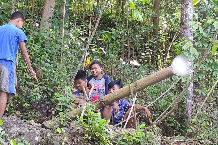 Bocah-bocah sebaya membuat meriam udara yang mereka sebut sebagai “long pring” di Kalurahan Sidomulyo, Kapanewon Pengasih, Kabupaten Kulon Progo, Daerah Istimewa Yogyakarta. Mereka mencari bambu sepelukan di bukit-bukit, membawanya pulang, lalu membuat long pring ini.