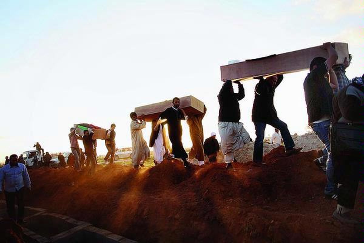 Sejumlah pria  mengusung peti jenazah korban yang ditemukan di dalam kuburan massal untuk dimakamkan kembali di Benghazi, Libya, Senin (5/3). Ribuan pelayat berkumpul di Benghazi, Senin, untuk memakamkan kembali 155 jenazah dari kuburan massal warga yang tewas dalam pertempuran melawan pasukan mantan pemimpin Libya, Moammar Khadafy, tahun lalu. Kuburan massal itu adalah yang terbesar yang ditemukan dari konflik yang berakhir dengan terbunuhnya Khadafy, Oktober 2011.