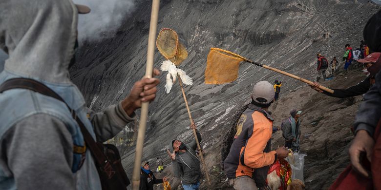 Villagers use nets to catch offerings thrown by members of the Tengger sub-ethnic group in the crater of the active Mount Bromo volcano as part of the Yadnya Kasada festival in Probolinggo, East Java province on June 16, 2022. Juni Kriswanto / AFP