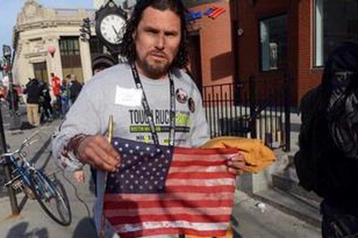 Carlos Arredondo, membawa bendera AS yang berlumuran darah tidak jauh dari lokasi ledakan bom Maraton Boston, 15 April 2013.