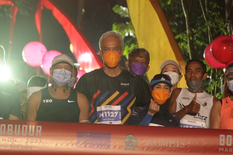 Gubernur Jawa Tengah, Ganjar Pranowo (masker oranye/kiri) dan istrinya, Atikoh (masker oranye/kanan), menjadi peserta lari Tilik Candi Borobudur Marathon 2021.