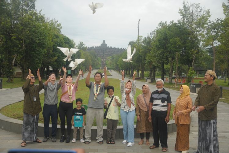 Wisatawan asal AS dan Cilacap, sebagai pengunjung pertama tahun 2023, melepas burung Merpati di Taman Wisata Candi Borobudur Magelang, Jawa Tengah, Minggu (1/1/2023).