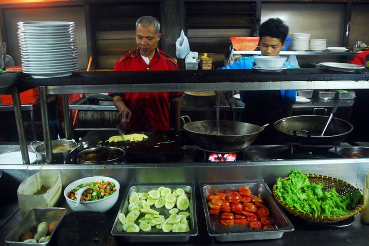 Dua orang koki karyawan rumah makan Rindu Alam, Cisarua, Puncak, Bogor , Jawa Barat, sedang memasak hidangan untuk disajikan kepada pelanggan, Kamis (30/11/2017)