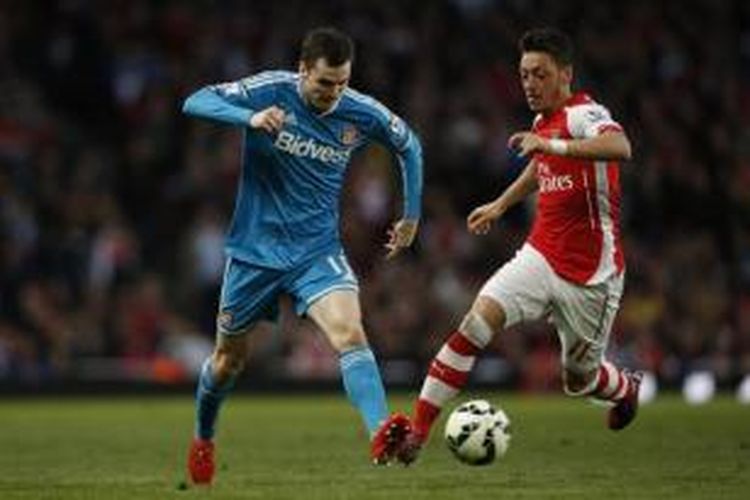 Gelandang Sunderland, Adam Johnson (kiri), gelandang Arsenal Arsenal, Mesut Oezil (kanan), dalam laga Premier League di Stadion Emirates, London, Rabu (20/5/2015).