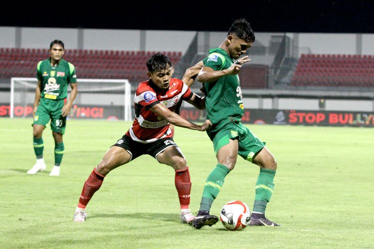 Pemain Madura United M Riski Afrisal menjaga ketat pemain Persebaya Surabaya Arief Catur pada laga pekan ke-16 Super league 2025-2026 yang berlangsung di Stadion Gelora Ratu Pamelingan Pamekasan, Sabtu (3/1/2026) malam.