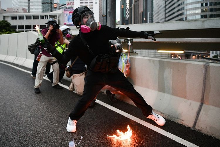 Salah seorang peserta unjuk rasa Hong Kong bersiap melemparkan bom molotov dalam aksi demontrasi pada Sabtu (31/8/2019).