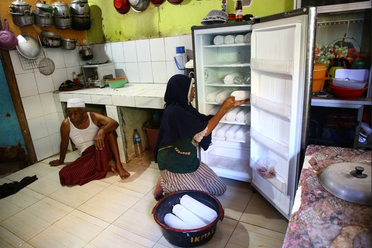 Wirnawati (31) mempersiapkan es batu dagangannya di Dusun Tanjung Keramat, Desa Papagarang, Kecamatan Komodo, Manggarai Barat, Nusa Tenggara Timur, Sabtu (2/10/2021). Keberadaan listrik PLN melalui PLTS Papagarang membantu kegiatan ekonomi warga setempat.