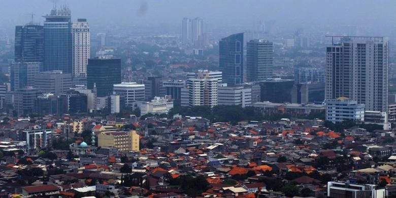 Kepadatan permukiman penduduk berlatar belakang gedung bertingkat terlihat dari ketinggian di Jakarta, Senin (12/12/2011).