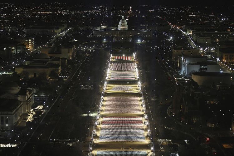 Gedung Capitol AS dipersiapkan untuk upacara pelantikan Presiden terpilih Joe Biden saat Field of Flags diterangi di National Mall pada hari Senin, 18 Januari 2021 di Washington, DC. Sekitar 191.500 bendera akan menutupi sebagian dari National Mall dan akan mewakili orang Amerika yang tidak dapat melakukan perjalanan ke Washington, untuk pelantikan Biden.