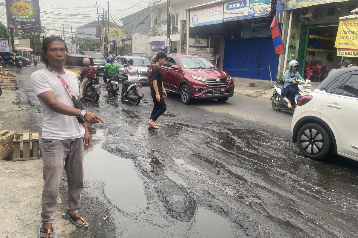 Warga tengah menunjukkan kerusakan Jalan Raya Kodau, Kelurahan Jatimekar, Kecamatan Jatiasih, Kota Bekasi
