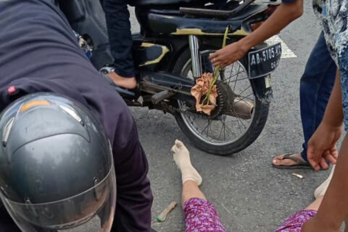 Warga mendokumentasikan tragedi ketika seorang perempuan setengah baya berbaring di aspal, sementara roknya melilit gir motor yang ditumpanginya. Peristiwa terjadi di Wates, Kulon Progo, Daerah Istimewa Yogyakarta.