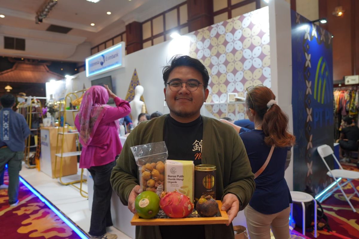 Ade Rizki Hermawan, Business Development Mega Inovasi Organik berfoto dengan produk mereka. 