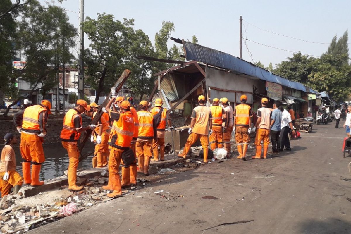 Petugas PPSU mengangkut puing-puing enam warung yang roboh di Jalan Jembatan Gambang Raya, Pejagalan, Rabu (24/10/2018). Warung-warung itu roboh, Selasa kemarin.