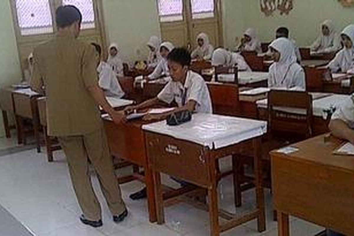 Guru pengawas ruangan di SMA Negeri 1 Pamekasan membagikan soal Bahasa Indonesia yang sudah difoto copy karena tertukar.