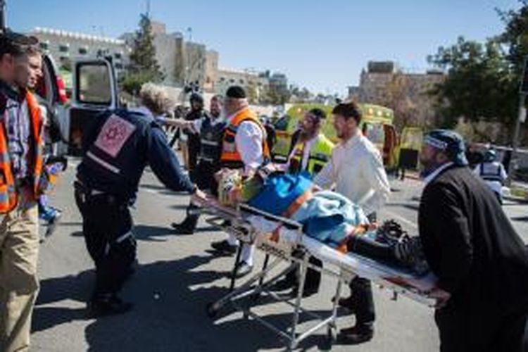 Tim paramedis membawa seorang korban aksi penabrakan mobil di Jerusalem, Jumat (6/3/2015). Sebelumnya, seorang pemuda menabrakkan mobilnya ke arah para pejalan kaki di Jerusalem sebelum mencoba menikam mereka.