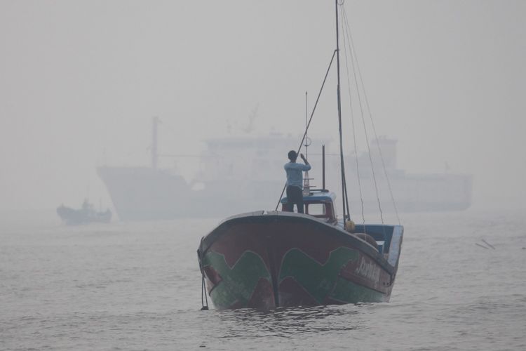 Sejumlah nelayan beraktivitas di atas kapal di kawasan perairan Pelabuhan Jetty Meulaboh, Aceh Barat, Aceh, Kamis (27/7/2017). Kabut asap akibat kebakaran lahan gambut di sejumlah wilayah di Aceh Barat menyebabkan terganggunya aktivitas nelayan di perairan karena faktor jarak pandang yang hanya berkisar 15 sampai 30 meter. 