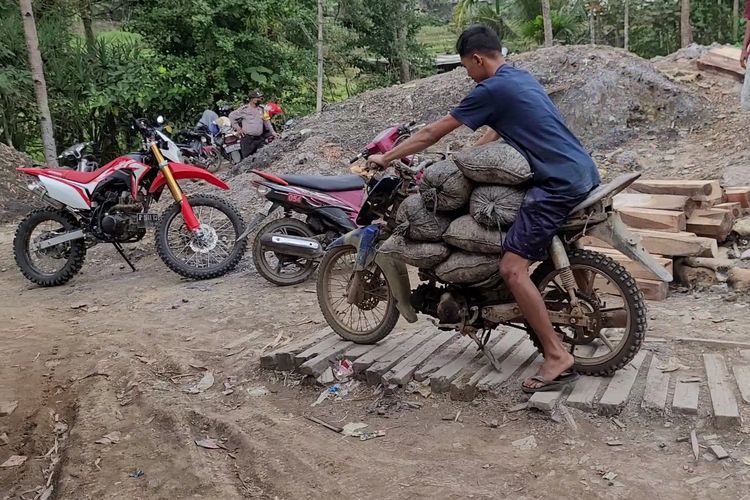 Penambang mengangkut material tambang menggunakan sepeda motor di Grumbul Tajur, Desa Pancurendang, Kecamatan Ajibarang, Kabupaten Banyumas, Jawa Tengah, Selasa (8/8/2023).
