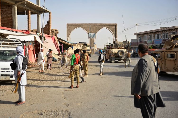 Dalam foto yang diambil pada 12 Agustus 2018 ini terlihat pasukan Afghanistan dan milisi bersenjata berada di sepanjang jalan dekat kota Ghazni. 