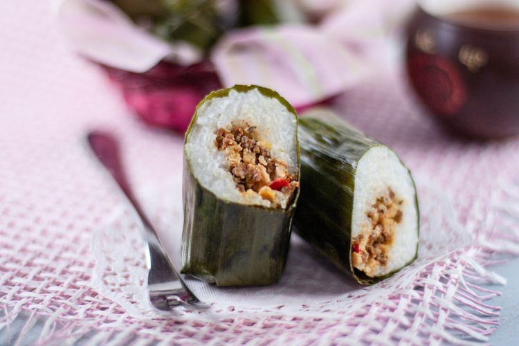 Ilustrasi arem-arem, terbuat dari nasi dan santan dalam bungkus daun pisang. Isinya sambal tempe. 