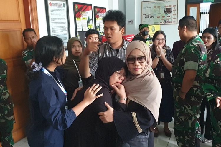 Fitriyani, ibu MAF (13), menangis di luar ruang sidang Sisingamangaraja XII di Pengadilan Militer I-02, Jalan Ngumban Surbakti, Kota Medan pada Kamis (7/8/2025). 