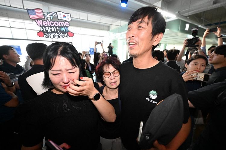 Seorang pekerja Korea Selatan (kanan), yang ditahan dalam penggerebekan imigrasi AS di pabrik Hyundai-LG di Ellabell, Georgia, disambut oleh keluarganya setelah kembali dari Atlanta di tempat parkir Bandara Internasional Incheon, Incheon, pada 12 September 2025. 