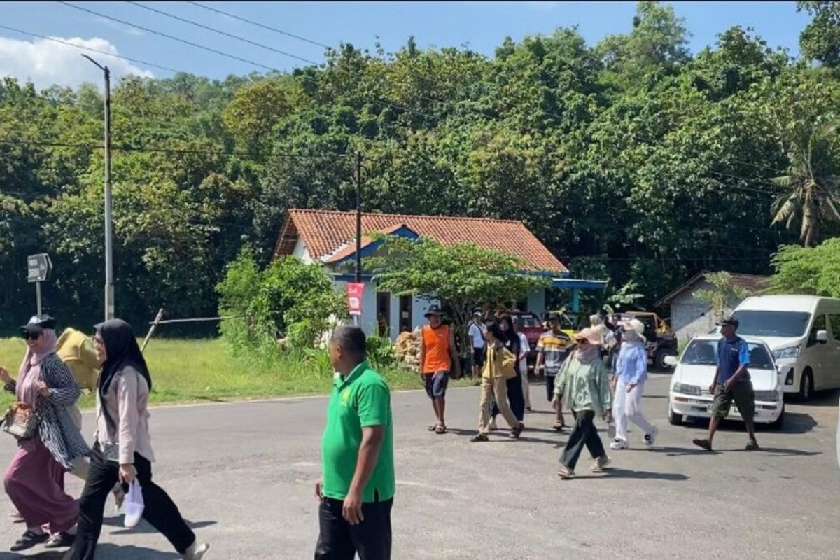 Wisatawan jalan kaki di sekitar Pertigaan jalan menuju Pantai Drini, Gunungkidul. Minggu (11/5/2025)