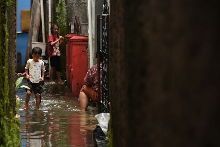 Warga tengah beraktifitas ditengah genangan air yang merendam pemukiman gang Warta Kelurahan Derwati Kecamatan Rancasari, Kota Bandung, selasa (4/3/2025)