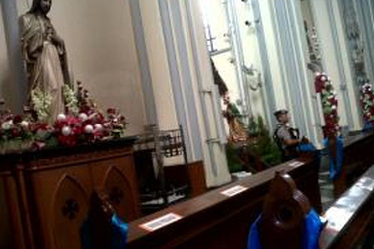 Salah satu anggota tim gegana sedang menyisir di dalam Gereja Katedral. Hal ini dilakukan untuk mengantisipasi benda-benda yang mencurigakan saat pada malam misa Natal, Selasa (24/12/2013).