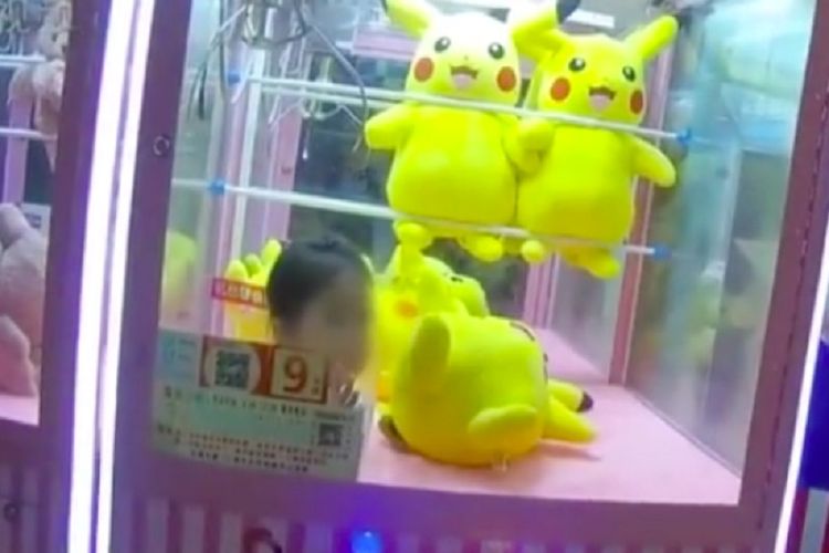 Gambar yang beredar di media sosial memperlihatkan seorang anak berusia tiga tahun terjebak di mesin capit berisi boneka Pikachu di China.
