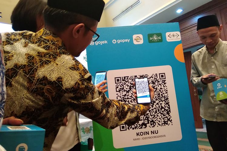 Asisten Direktur Divisi Perizinan SP dan Elektronifikasi KPw Bank Indonesia Ria Swandito saat melakukan scan QRIS di Jakarta, Selasa (17/12/2019).