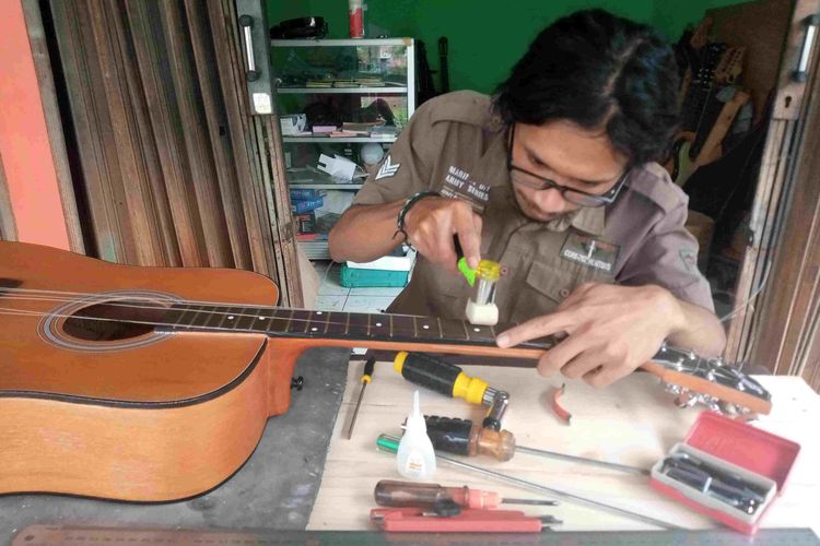Nurkholis menservis gitar miliki pelanggannya di Ruko UKM Kerep Ambarawa.
