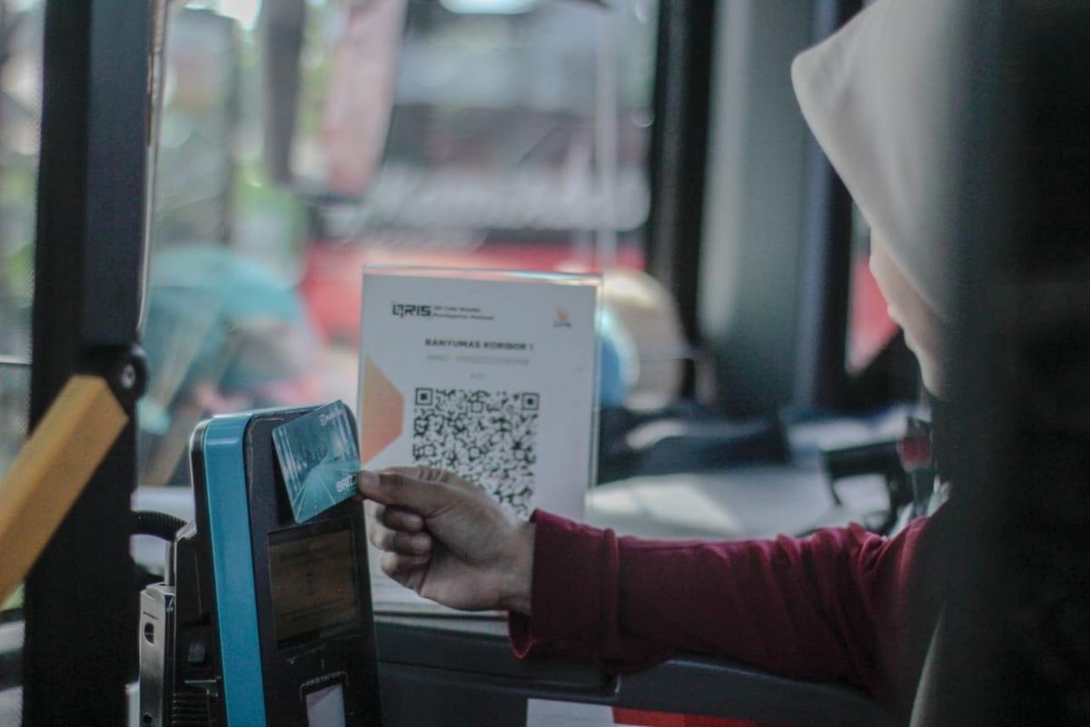 Terlihat salah seorang nasabah BRI sedang menggunakan BRIZZI untuk membayar ongkos transportasi umum