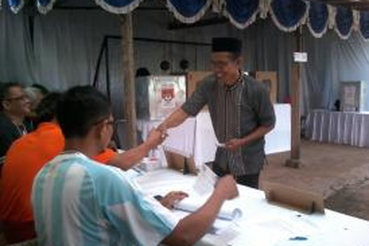 Salah satu warga mengambil surat suara dari panitia KPPS di TPS 011 RT 009/03 Kelurahan Gedong Kecamatan Pasar Rebo Jakarta Timur. Adapun konsep dekorasi dan kostum panitia, serba Piala Dunia 2014.