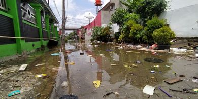 Sampah berserakan di permukaan air banjir di RW 011, Kelurahan Periuk, Kecamatan Periuk, Kota Tangerang, Banten. Senin (22/2/2021) siang. Banjir di lokasi itu sudah terjadi sejak Sabtu lalu dan sampai Selasa ini belum juga surut.Kompas.com