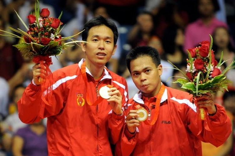 Markis Kido (R) and Hendra Setiawan of Indonesia celebrate with their gold medals in the men's badminton doubles event of the 2008 Beijing Olympic Games in Beijing on August 16, 2008.  Kido and Setiawan beat Cai Yun and Fu Haifeng of China 12-21, 21-11, 21-16.       AFP PHOTO/GOH CHAI HIN (Photo by GOH CHAI HIN / AFP)