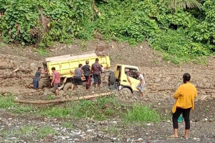 Seorang warga, Jumat (16/10/2020) melihat upaya penyelamatan kendaraan yang terbenam di lumpur akibat longsor di sepanjang jalan antara Desa Tangkura dan Desa Sangginora, Kecamatan Lore Peore, Kabupaten Poso, Sulteng. 