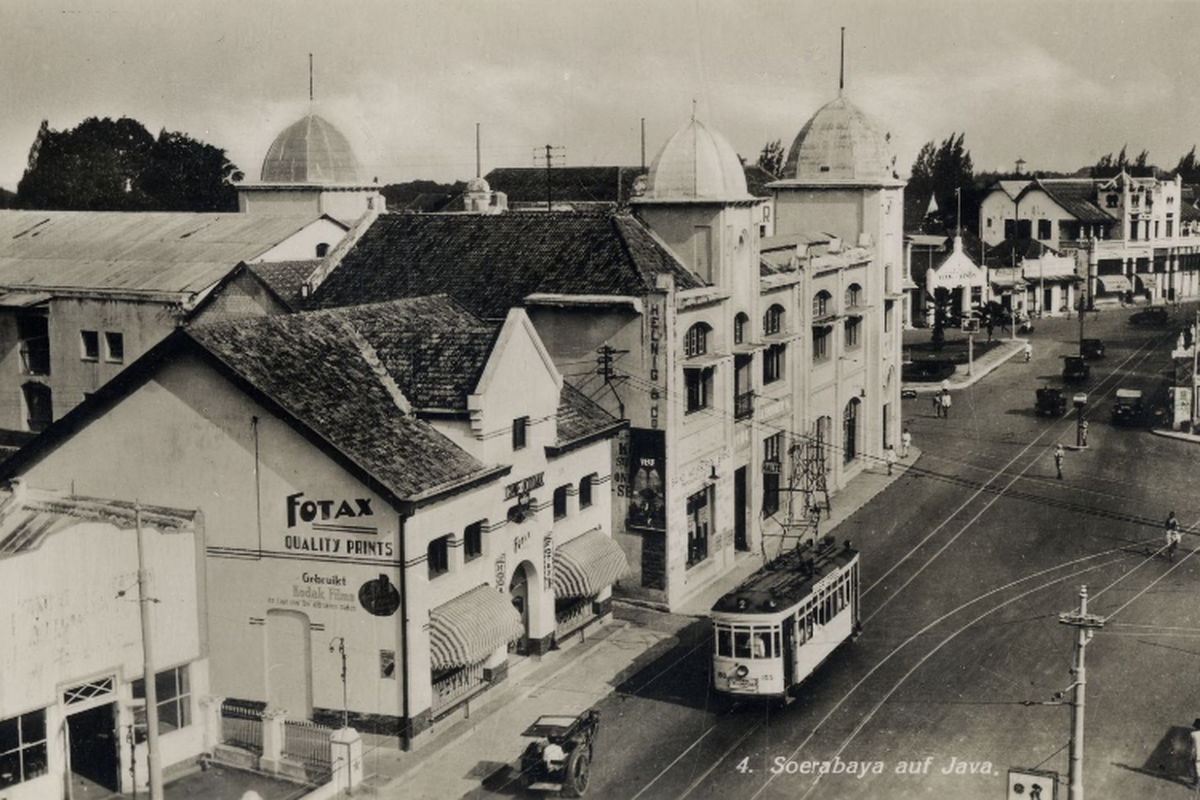Trem listrik melintas di Jalan Gemblongan, tepatnya depan Hotel Yamato (sekarang Hotel Majapahit), Fotax Fotografisch Magazijn, dan Atelier di sisi kiri. Foto diambil tahun 1938.