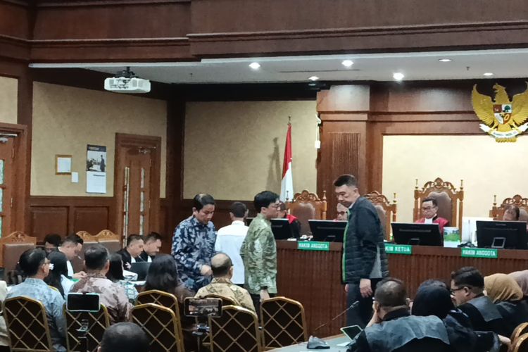 Komisaris PT Gojek Tokopedia TBK, Andre Sulistyo (batik biru) dan Co Founder Gojek, Kevin Aluwi saat diambil sumpah dalam sidang lanjutan kasus korupsi Chromebook dengan terdakwa Eks Mendikbudristek Nadiem Makarim di Pengadilan Tipikor Jakarta, Senin (23/2/2026). 