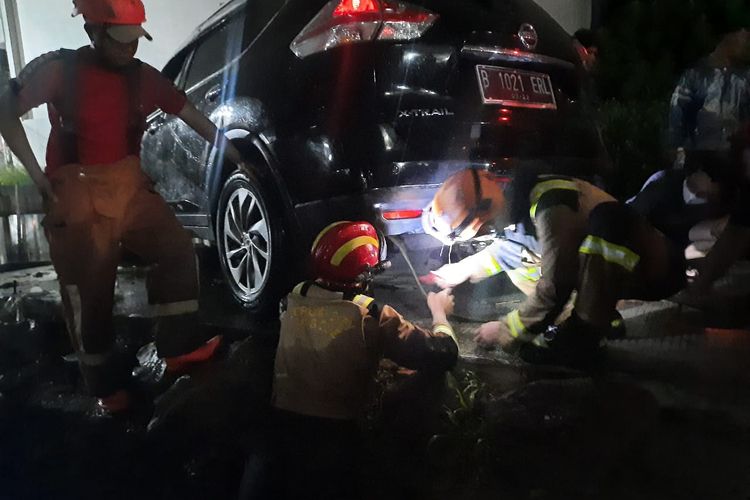 Damkar Kota Depok tengah mengevakuasi mobil yang terperosok ke sungai di perumahan Bukit Cengkeh 1, Tugu, Cimanggis, Depok pada Senin (18/4/2022).