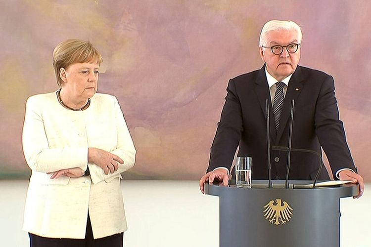 Kanselir Jerman Angela Merkel (kiri) berdiri di samping Presiden Frank-Walter Steinmeier yang sedang berpidato di Istana Bellevue, Kamis (27/6/2019).