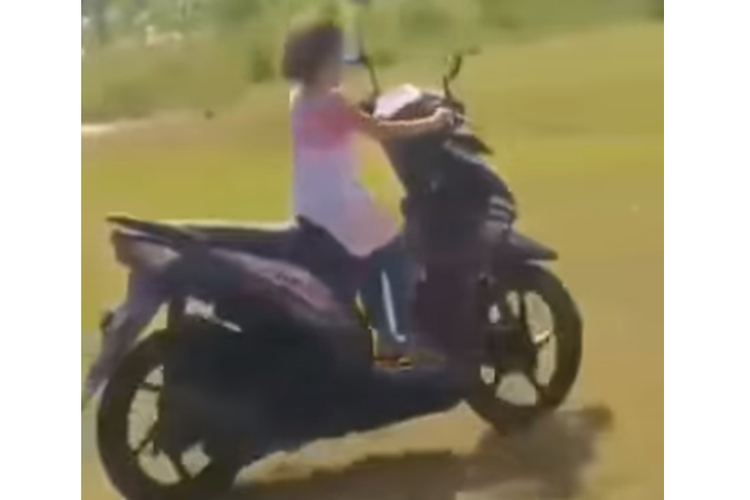 Tangkapan layar video bernarasi seorang anak kecil belajar mengendarai sepeda motor.