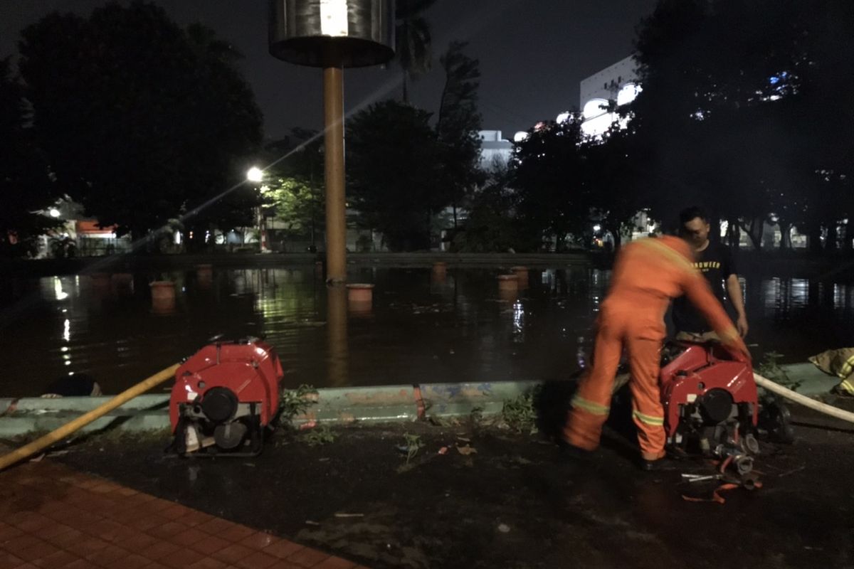 Petugas pemadam kebakaran menyedot air dari Kolam Taman Martha Tiahahu, Kebayoran Baru, Jakarta pada Sabtu (22/8/2020) malam untuk menyuplai air dan digunakan untuk memadamkan api yang membakar gedung Kejaksaan Agung.