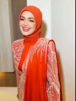 Siti Nurhaliza tampil memukau di Pestapora 2025 dengan hijab oranye terang, setelan berpayet, dan makeup soft glam yang elegan.