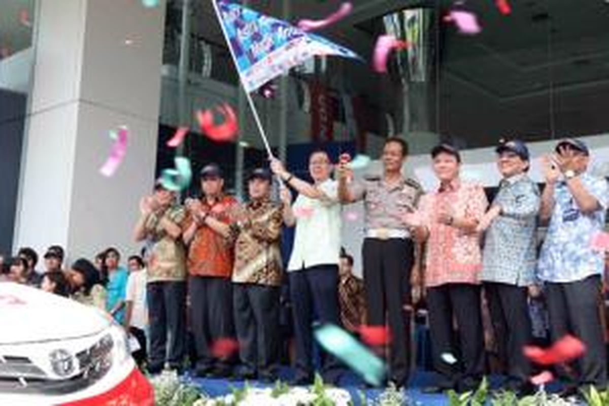 Presiden Direktur PT Astra International Tbk Prijono Sugiarto (memegang bendera) dan Kepala Bidang Pendidikan Masyarakat Korps Lalu Lintas Kepolisian Negara Republik Indonesia Kombes Pol Drs Pujiono Dulrahman MH (keempat kanan) bersama Direksi dan Eksekutif Astra melakukan pelepasan armada dan mekanik yang bertugas untuk Astra Holiday Campaign (AHC) 2014 di acara kick off AHC 2014, Rabu, 23 Juli 2014.