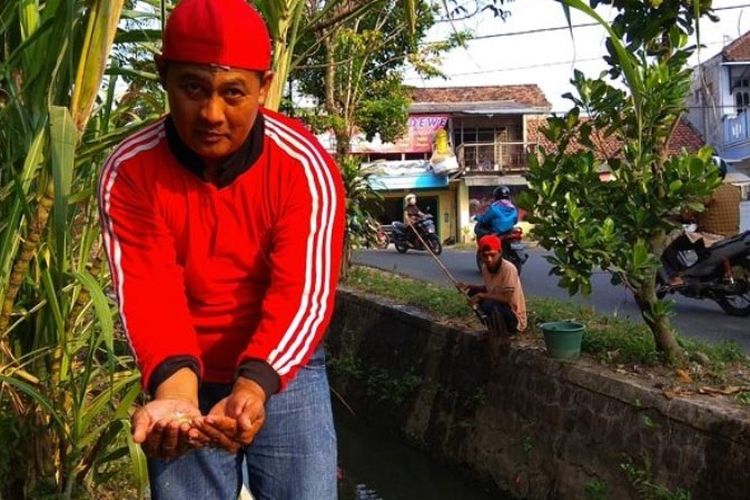 Suryanto menunjukkan ikan koi hasil tangkapannya. Warga menyebutkan, ribuan ikan koi tiba-tiba memenuhi sungai kecil di Dusun Karanggude, Desa Sobontoro, Kecamatan Boyolangu, Kabupaten Tulungagung, Jawa Timur.