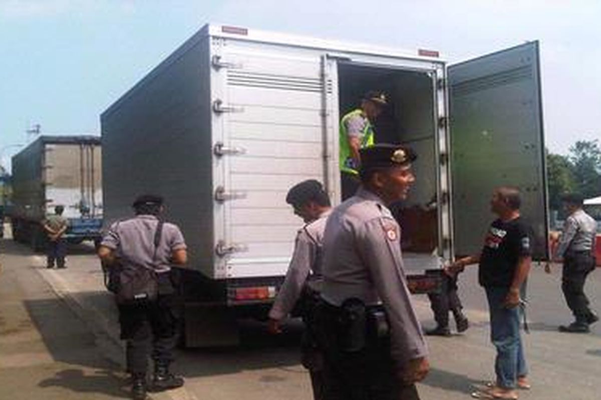 Polisi memeriksa beberapa truk di depan gerbang Tol Cikampek di Cikopo, Kabupaten Purwakarta, Jawa Barat, Selasa (27/3/2012).   