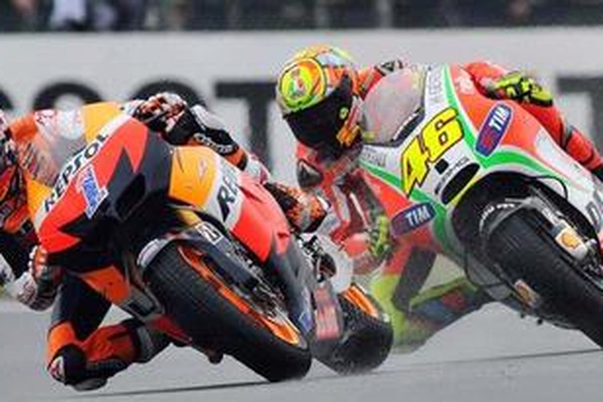 Pebalap Repsol Honda, Casey Stoner (kiri), bersaing dengan pebalap Ducati, Valentino Rossi, dalam perebutan posisi kedua GP Perancis, Minggu (20/5/2012). Rossi jadi pemenang dalam duel ini.